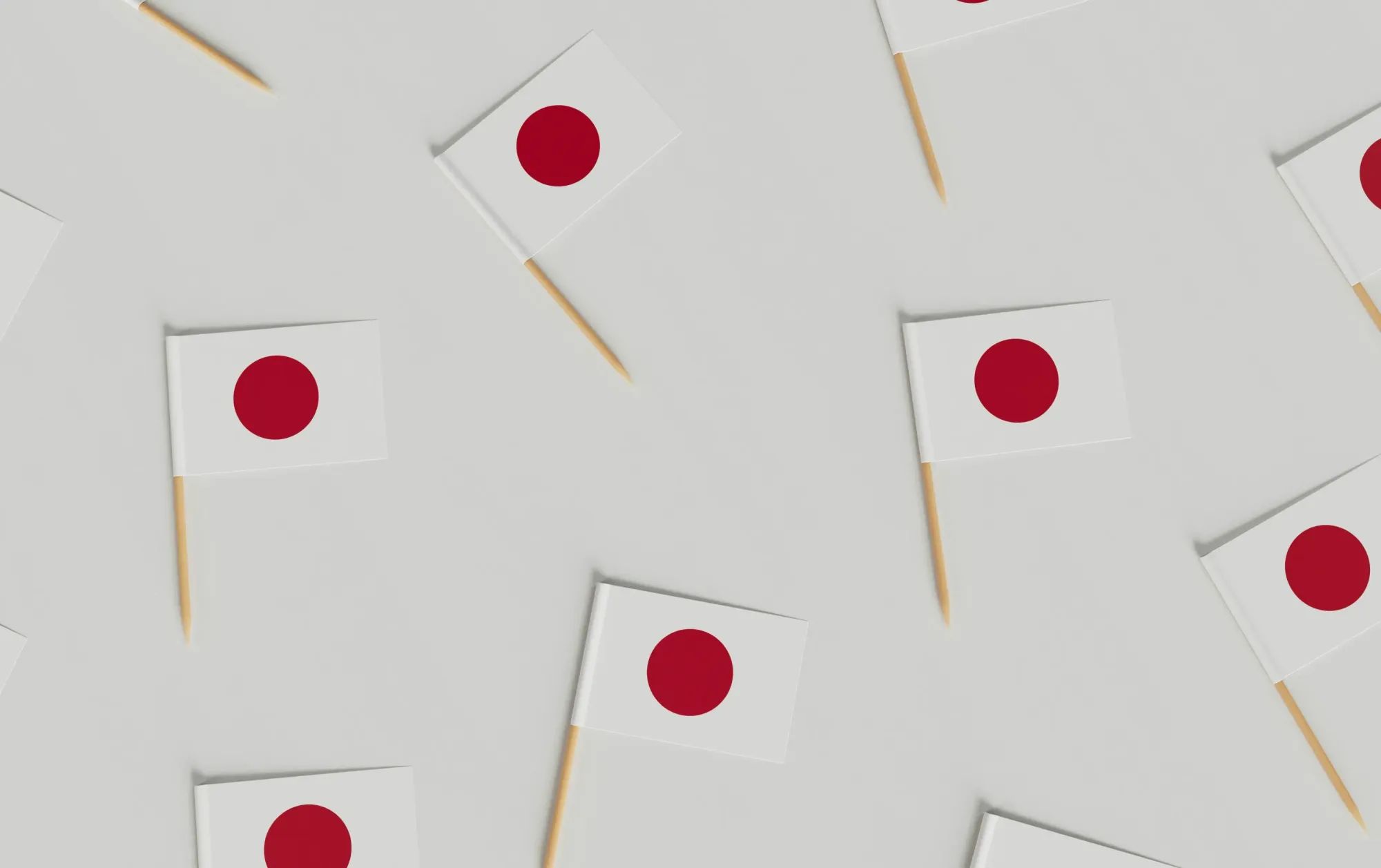 Japanese flag with Mount Fuji in background – national flag of Japan waving on a pole with inscriptions, set against the snow-capped peak of Mount Fuji.