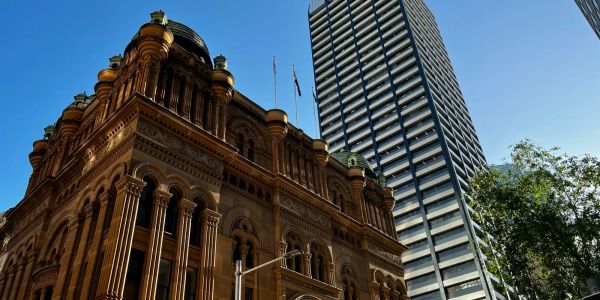 Historic building with columns next to a modern high-rise in a city center