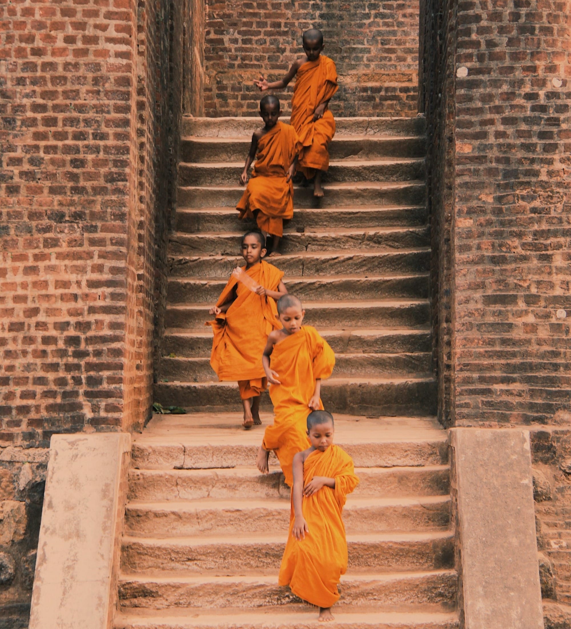 man in yellow jacket walking on gray concrete stairs