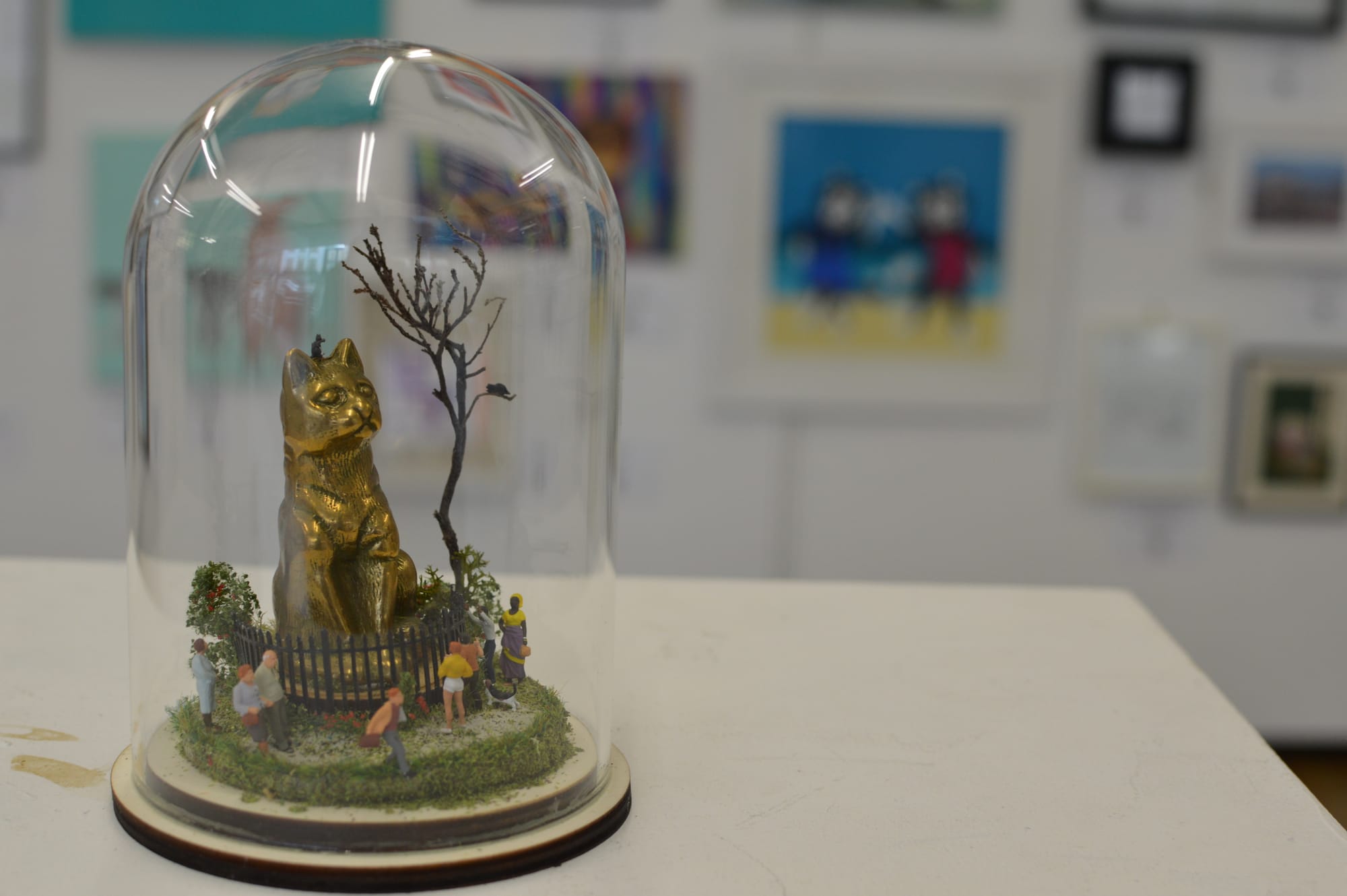 An artwork of a large golden cat enclosed in a terrarium