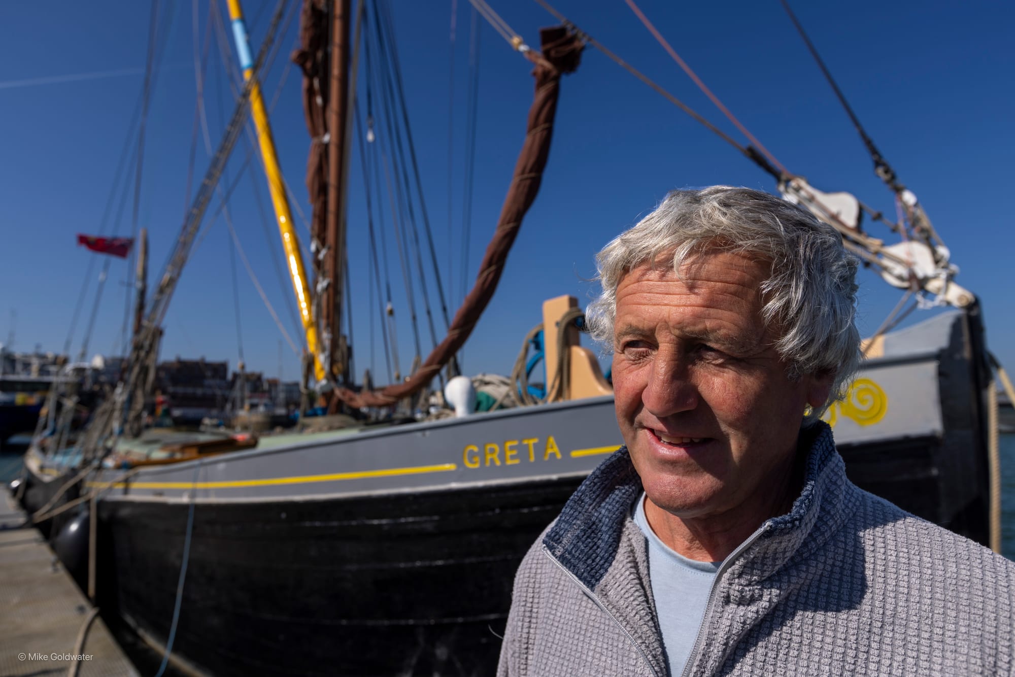 Man standing in front of old boat
