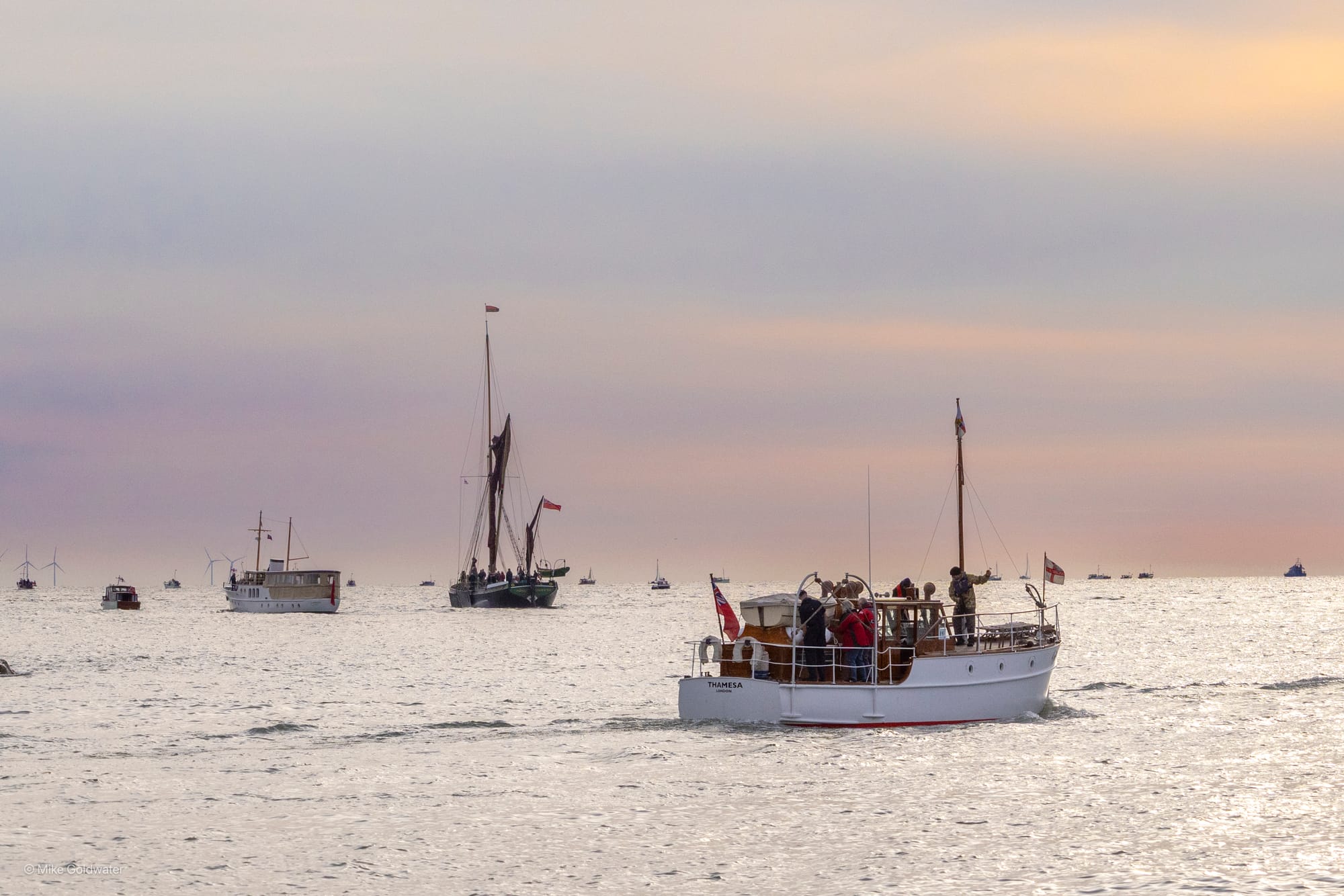 Three small boats on the sea at sunrise