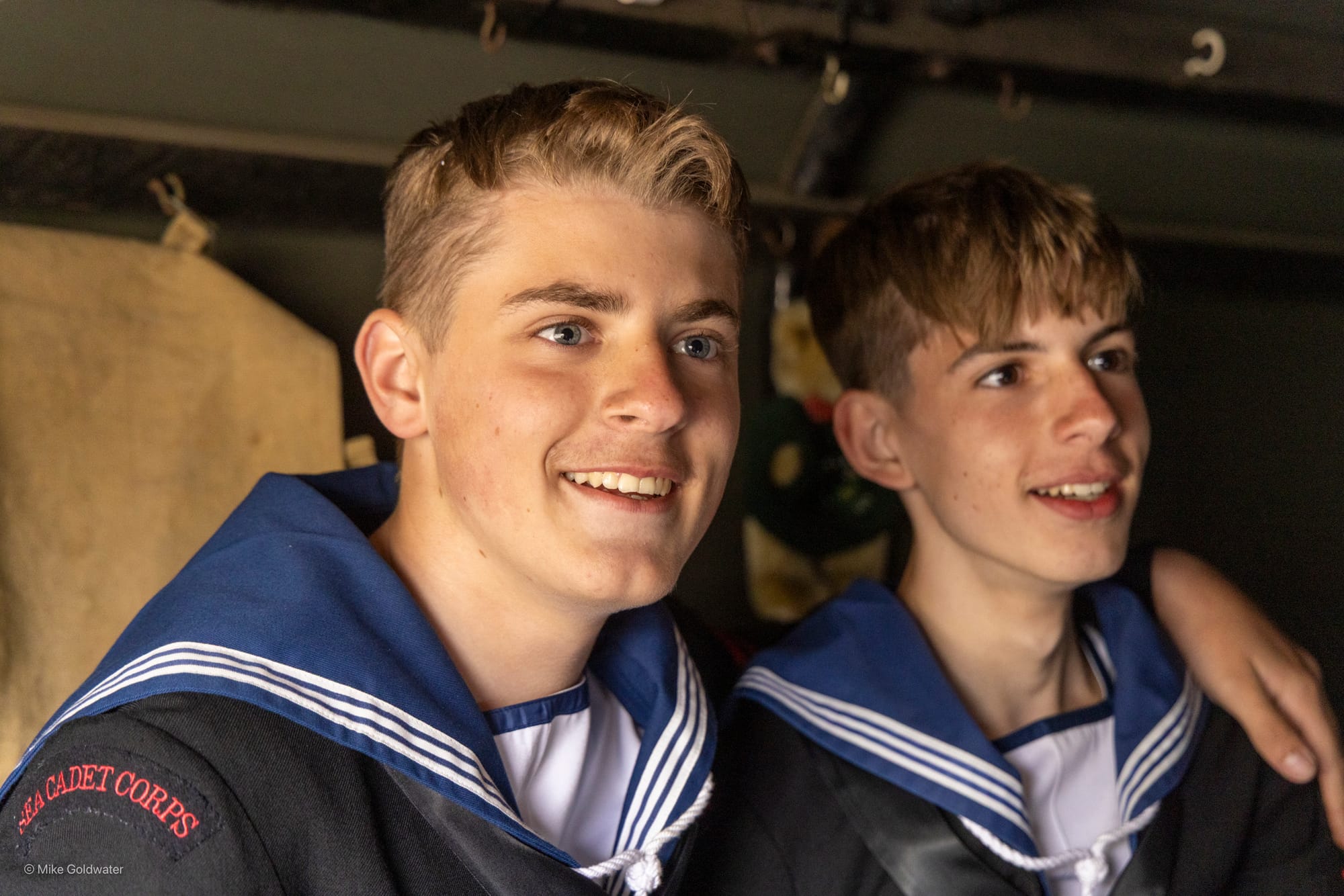 Two male teenagers dressed in a sailors uniform smiling