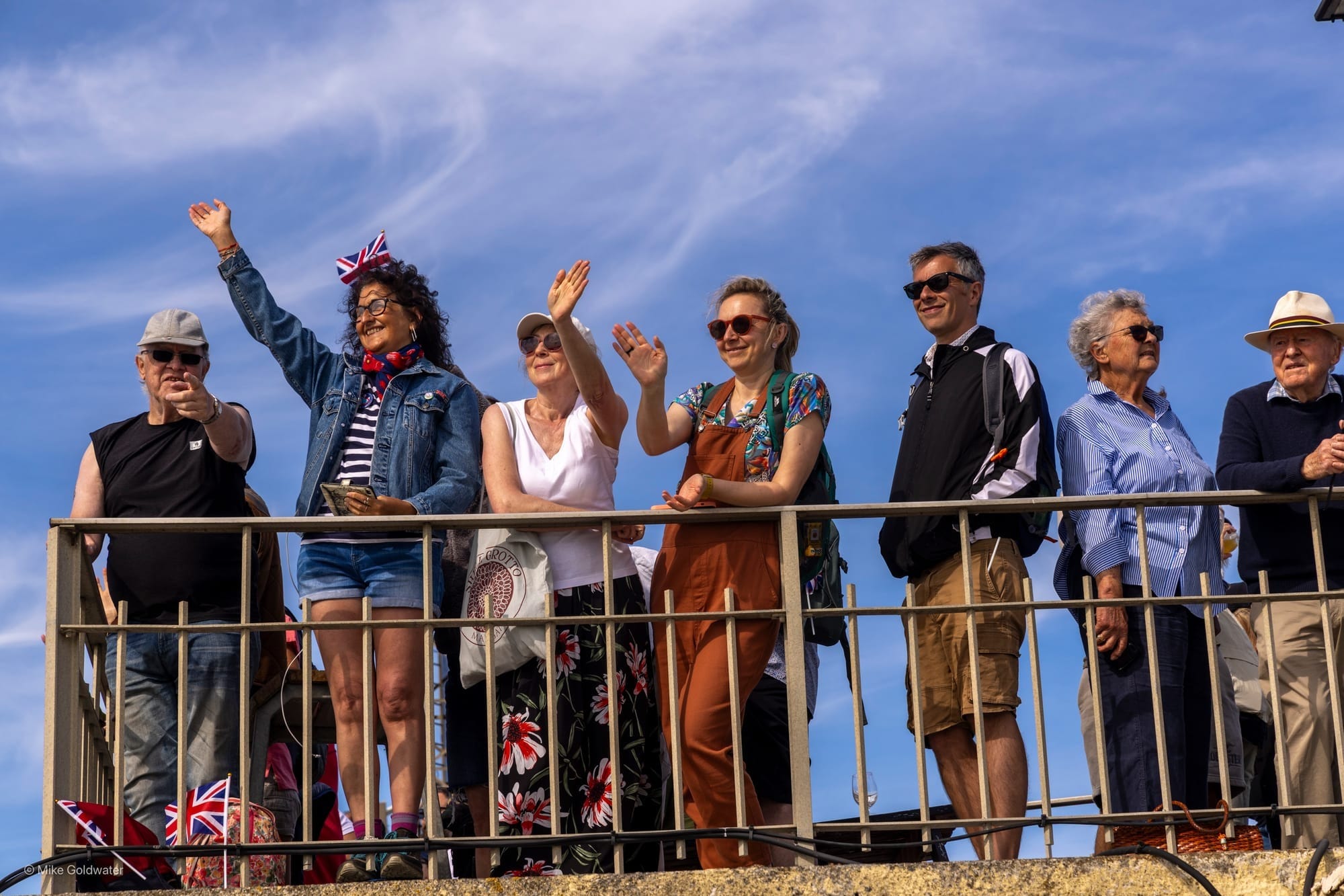 People standing at railing, waving