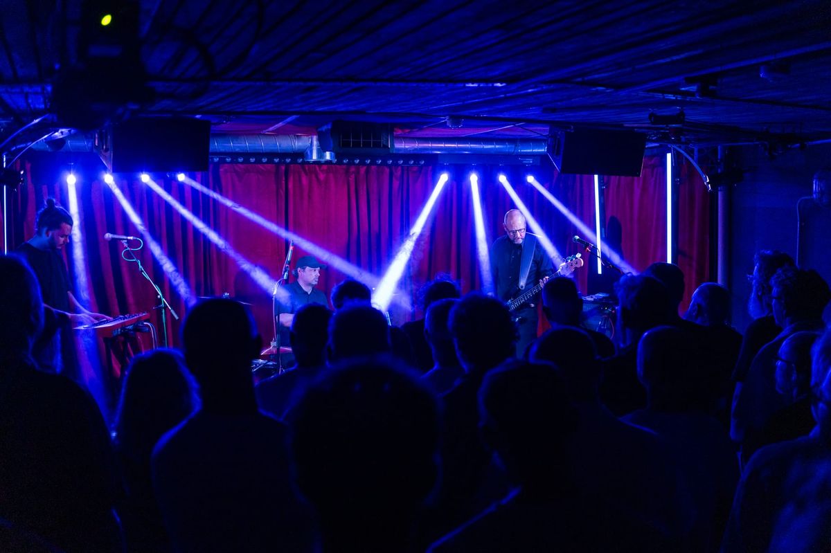 A band perform on stage in a small music venue