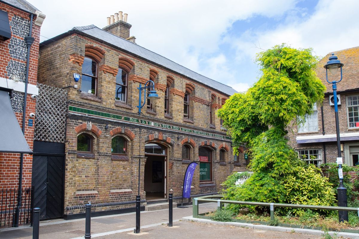 An old warehouse building. Tree in the foreground. Old street lights.