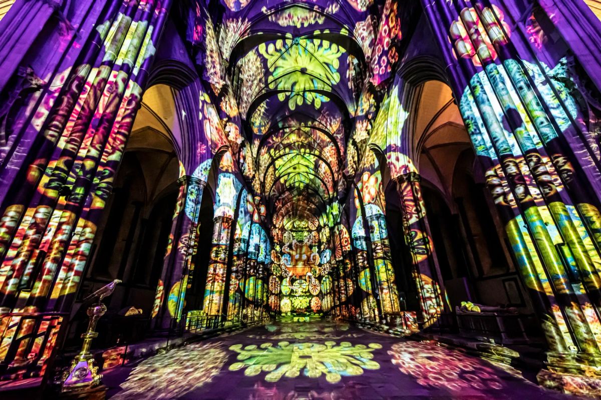 A cathedral is illuminated by multi-coloured shapes