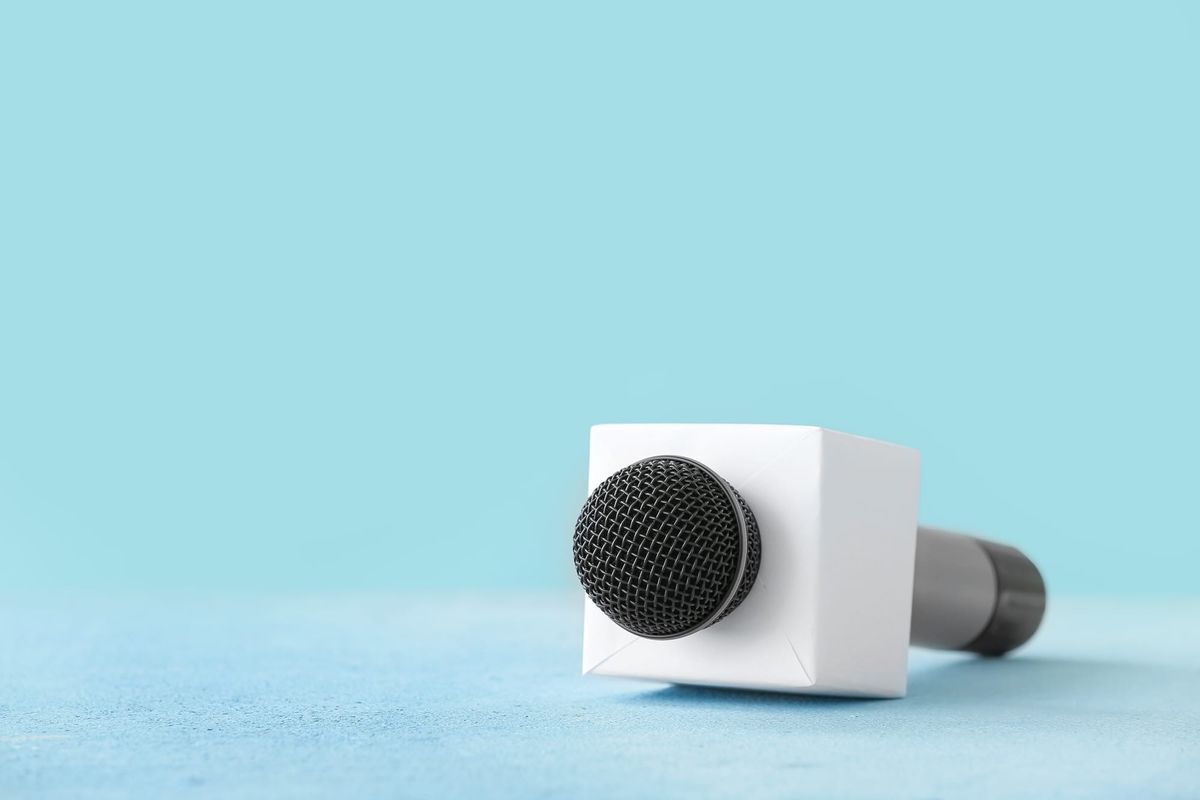 A microphone lies on its side against a blue background