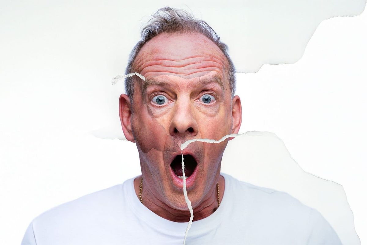 A torn up photograph of a shocked looking man