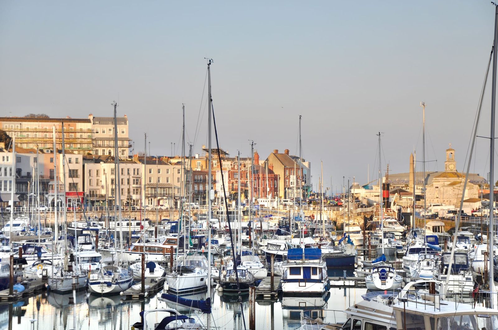 Boats sit in a harbour with buildings in the background