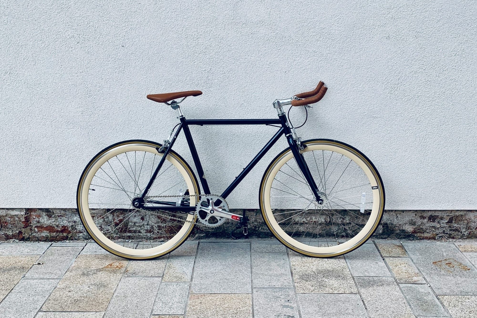 A bicycle leaning against a white wall