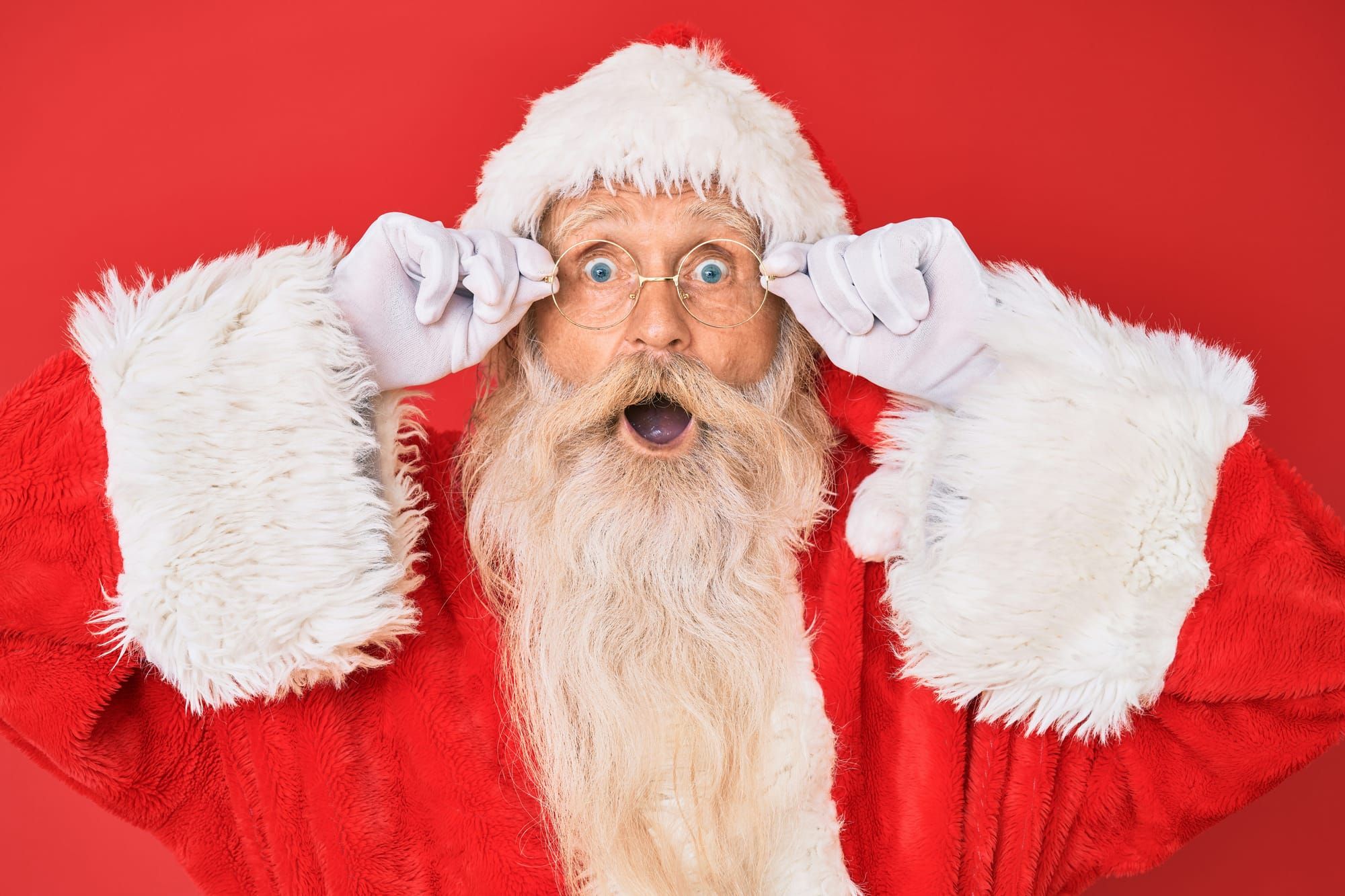 Santa adjusts his glasses in amazement 