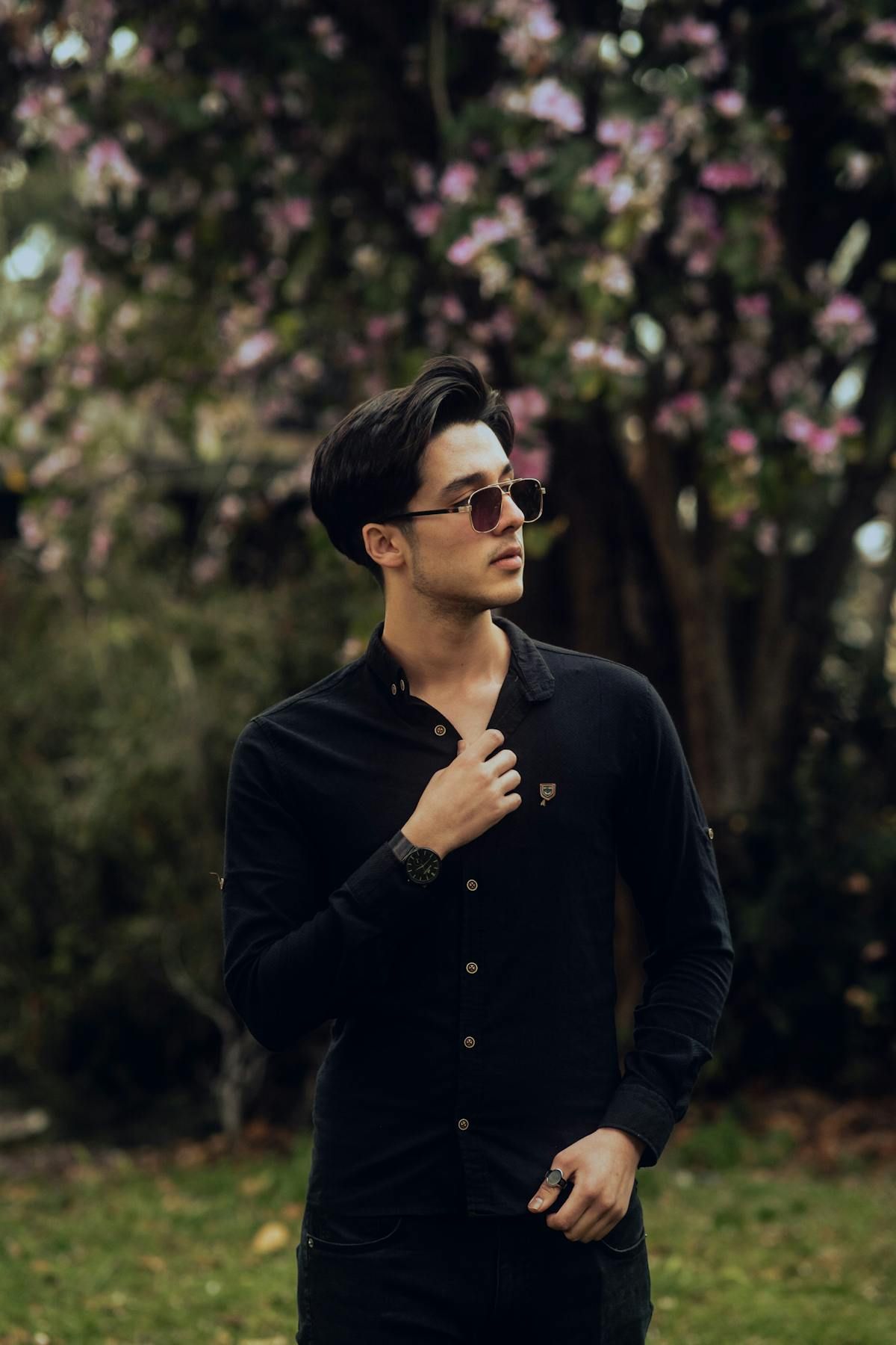 Young man in a single long sleeve button-down outdoors with spring blossoms, the comfortable single layer for 68 degree weather