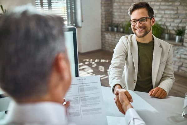 2 bărbați dau mâna, negociază salariul în Germania