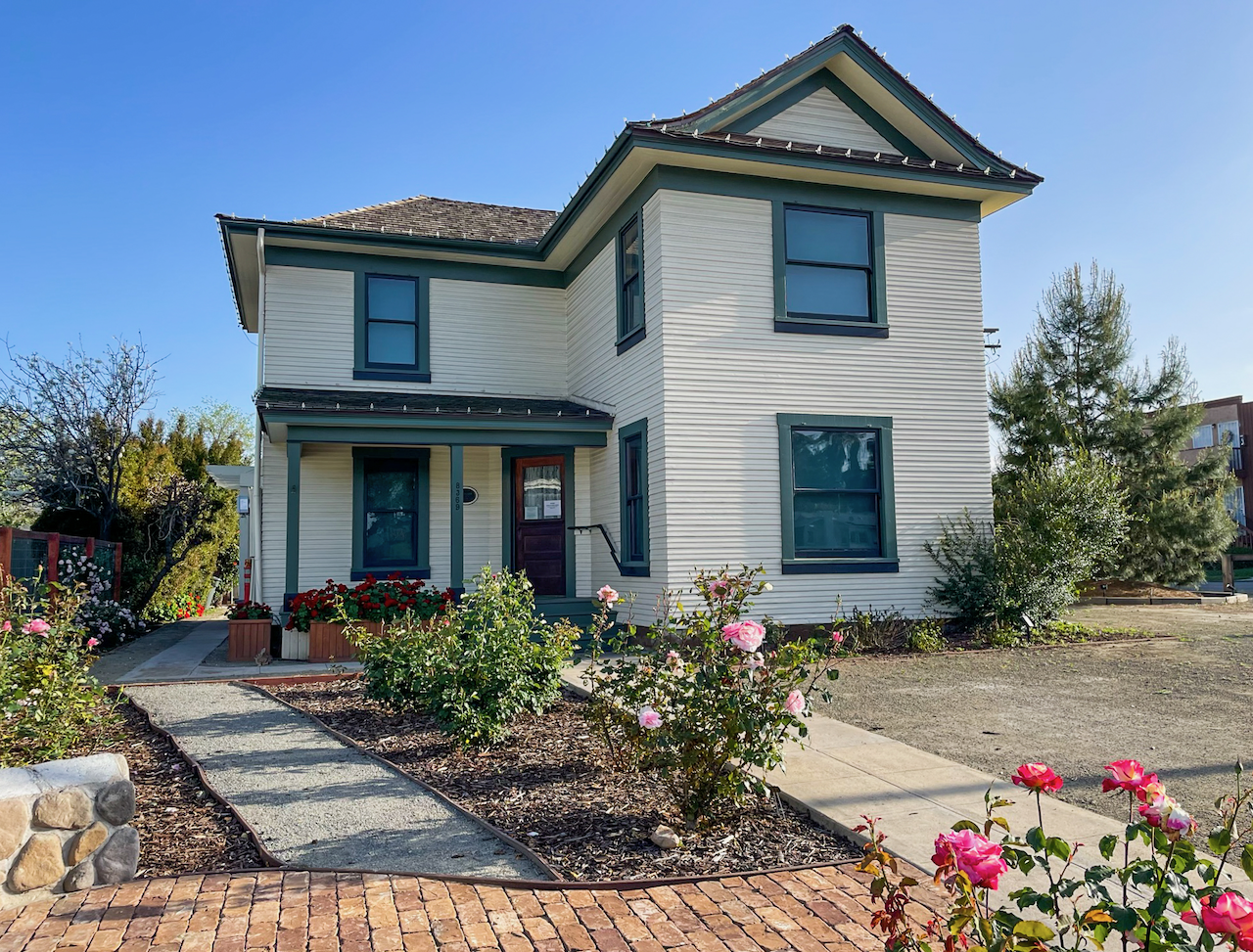 Early 20th century two story house with roses in garden