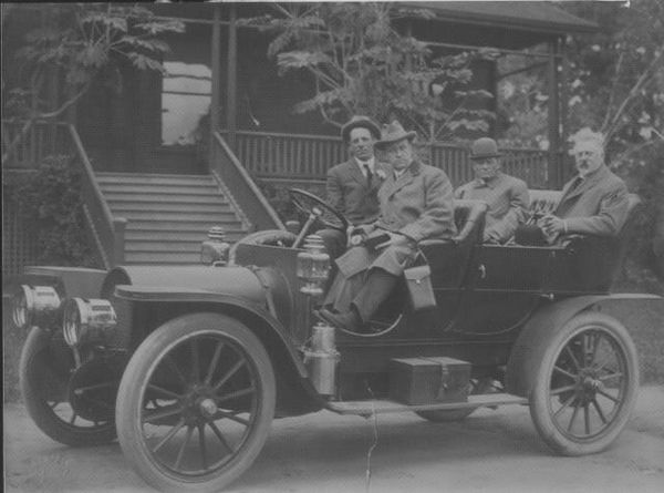 Open topped motor vehicle with four men 