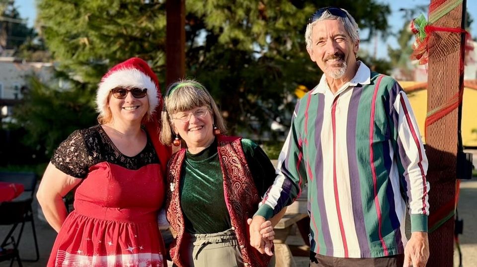 Three members dressed in red and green at party