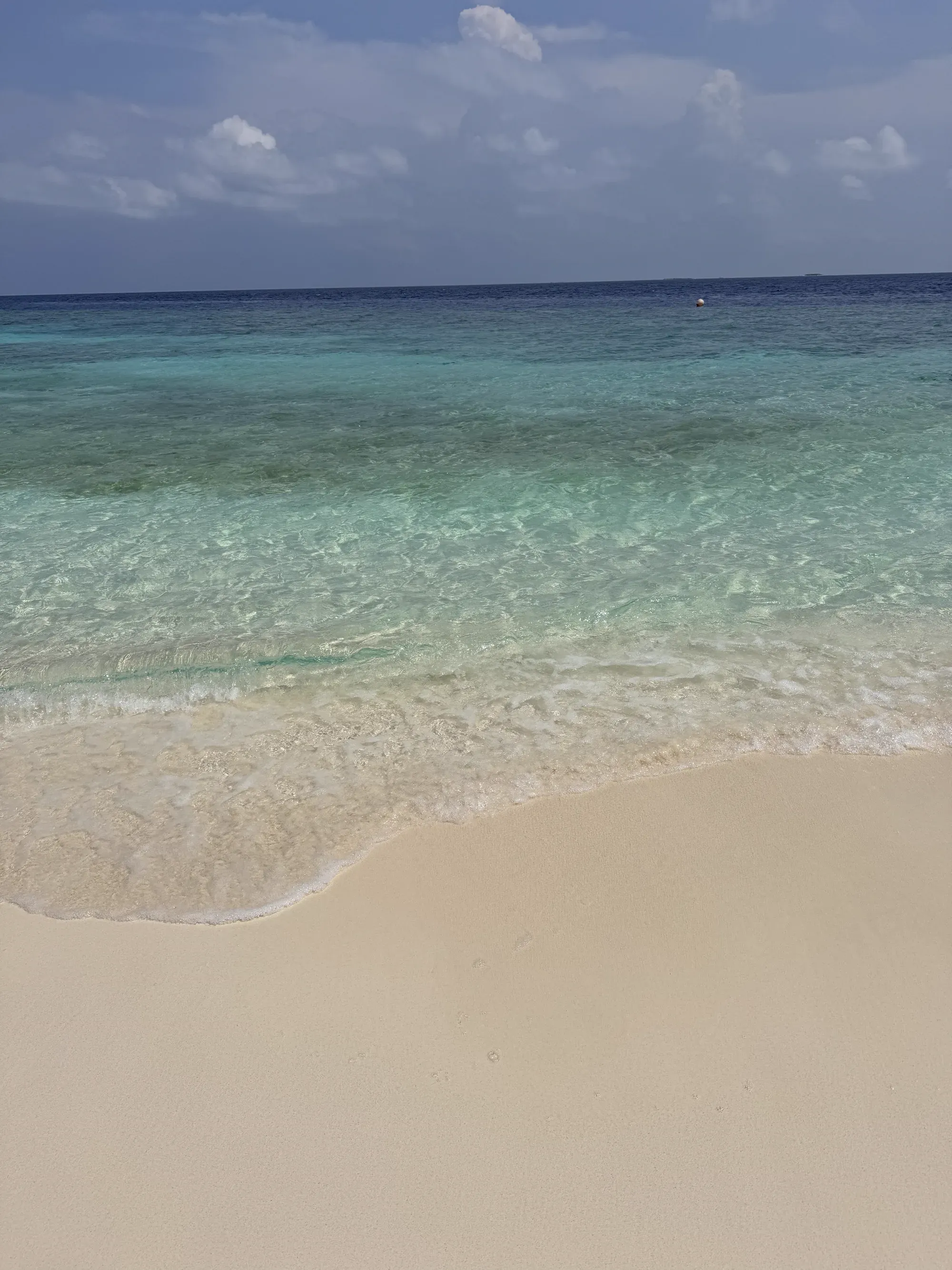 Crystal clear shallow water over reef at the beach at Emerald Maldives
