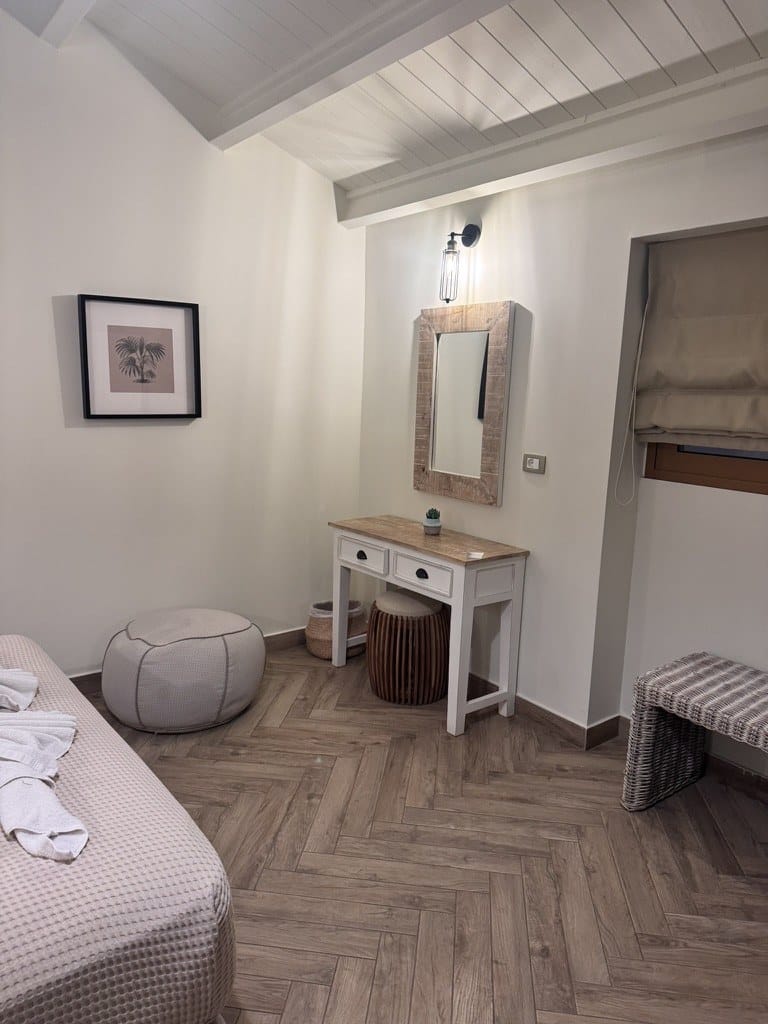 Boutique room dressing area with framed art, wooden mirror and dressing table at La Signora Hotel