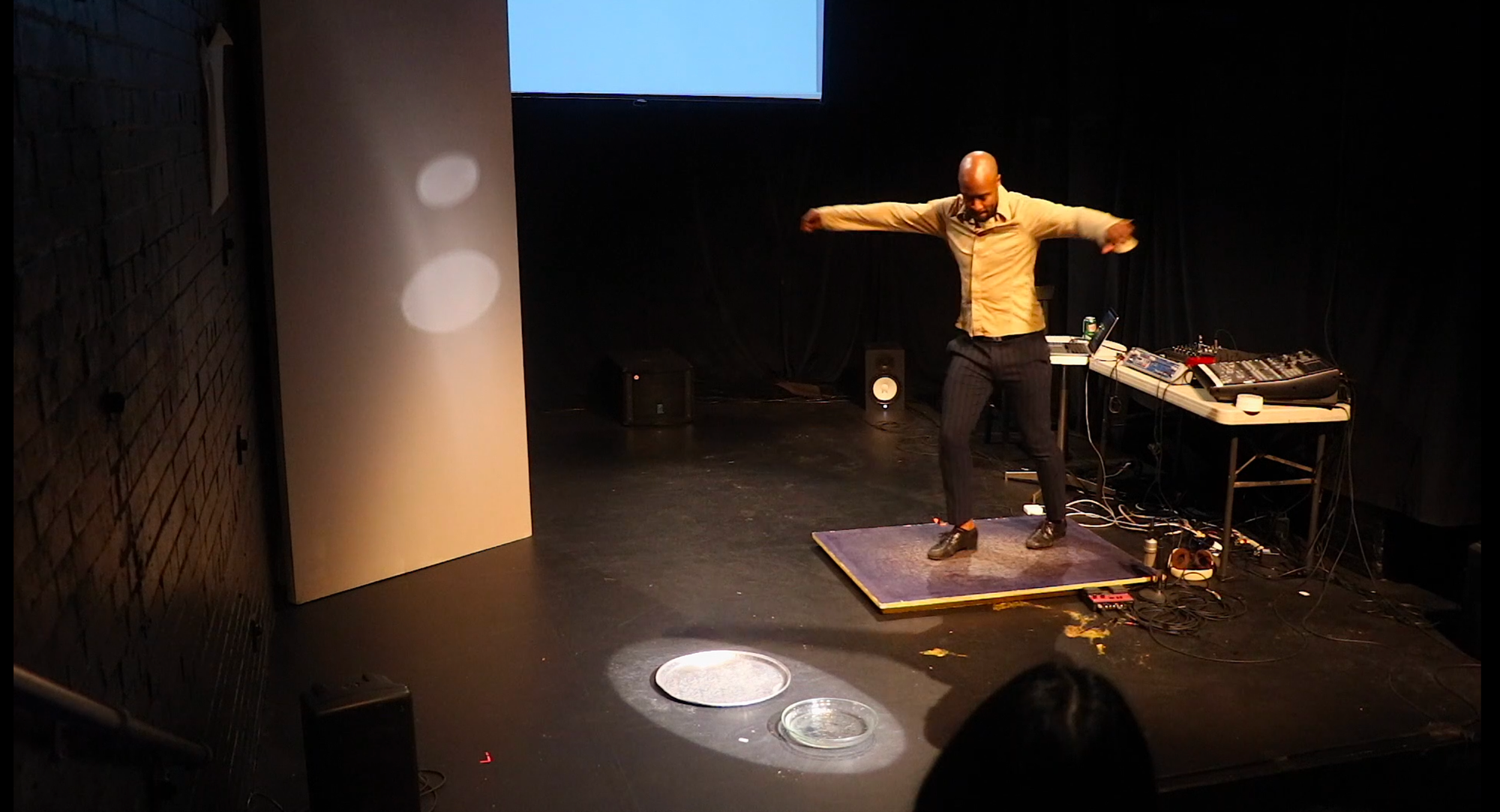 Travis Knights dances on a board connected to various technological equipment. 
