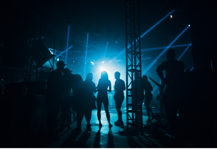 People in shadow hanging out backstage.
