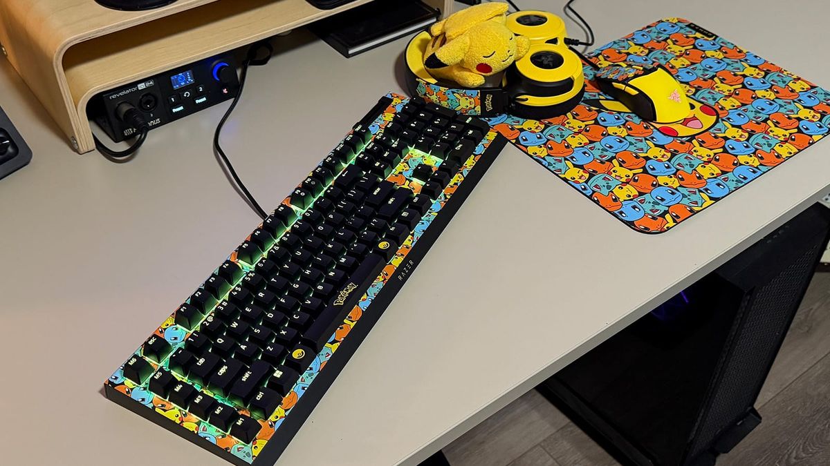 Desk with pokemon keyboard, headset, mouse, and mousepad
