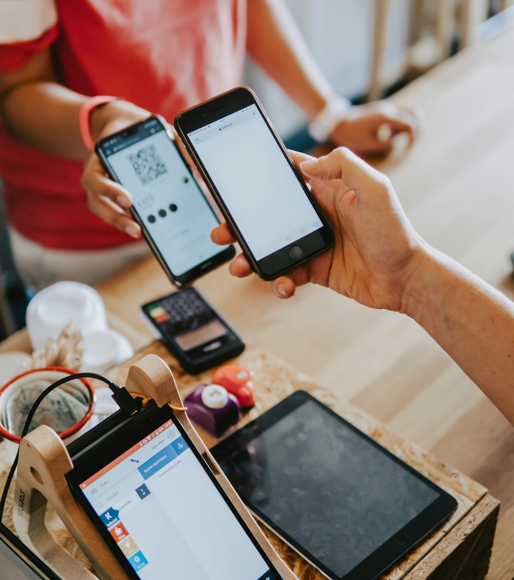 two person's hands holding turned-on phones