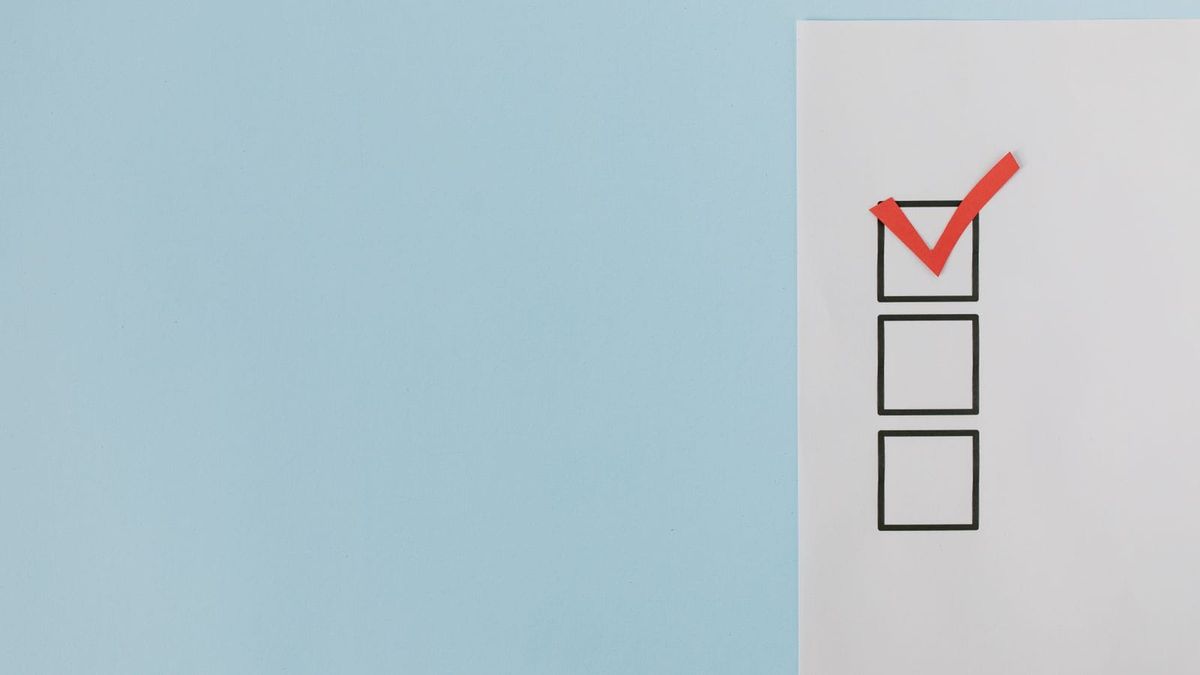 A red tick mark appears in one of three square checklist boxes on white paper.