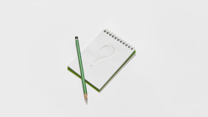 A notepad with a question mark drawn on it.