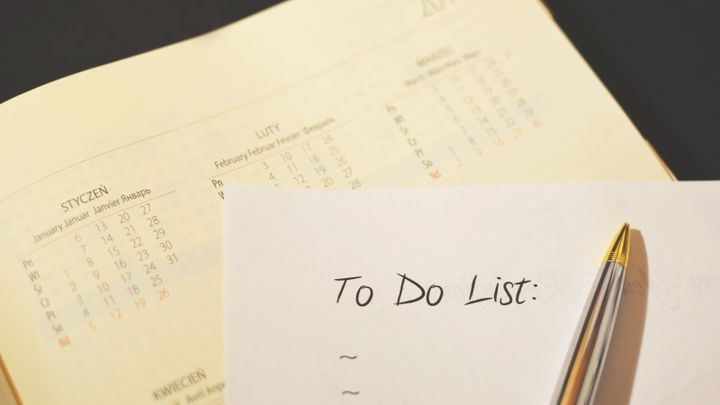 A pen resting on a paper to-do checklist.