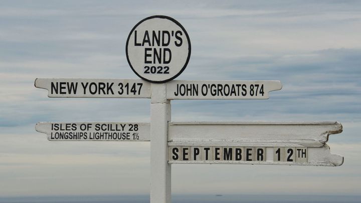 A signpost with multiple directional arrows against a bright sky.