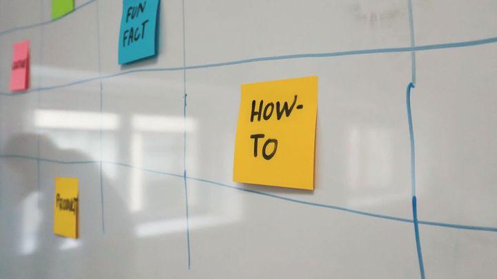 Colorful sticky notes arranged on a whiteboard schedule.