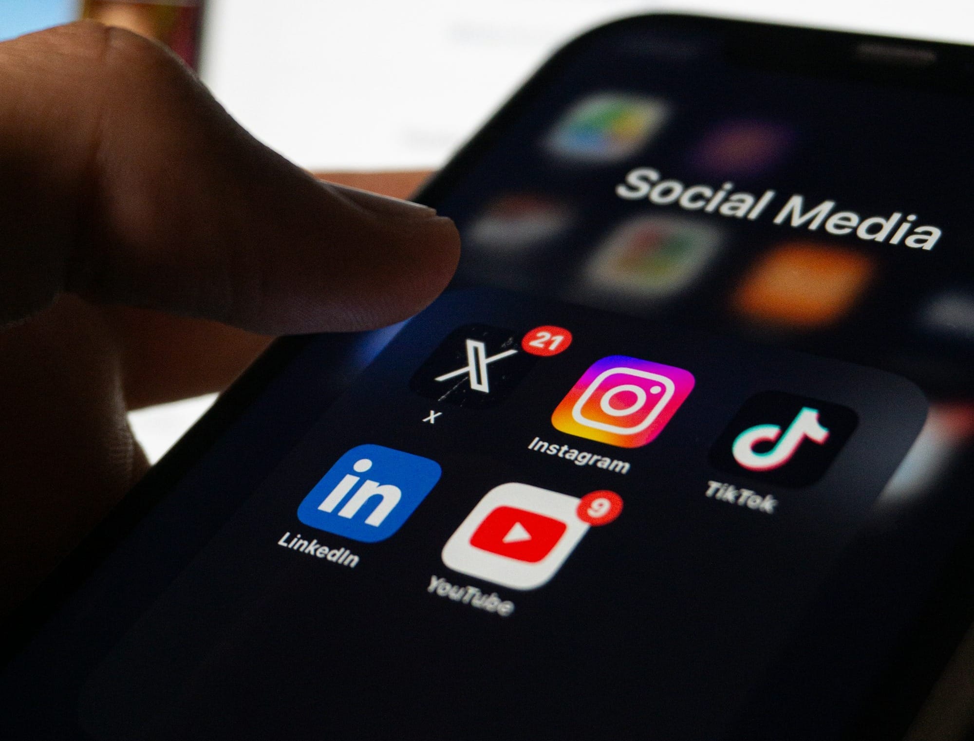 A person holding a smart phone with social media on the screen