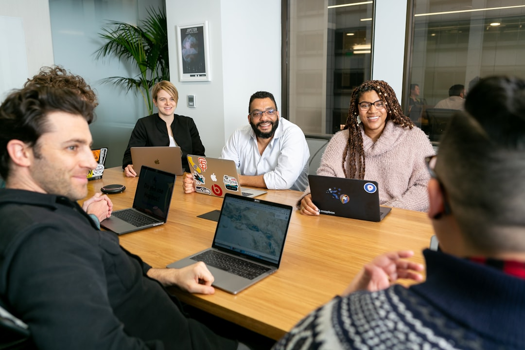 team collaboration around laptop office meeting