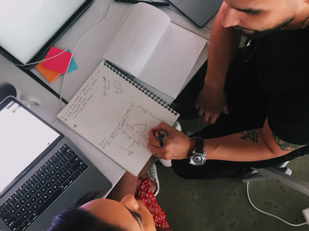 team collaborating around a laptop with charts and spreadsheets