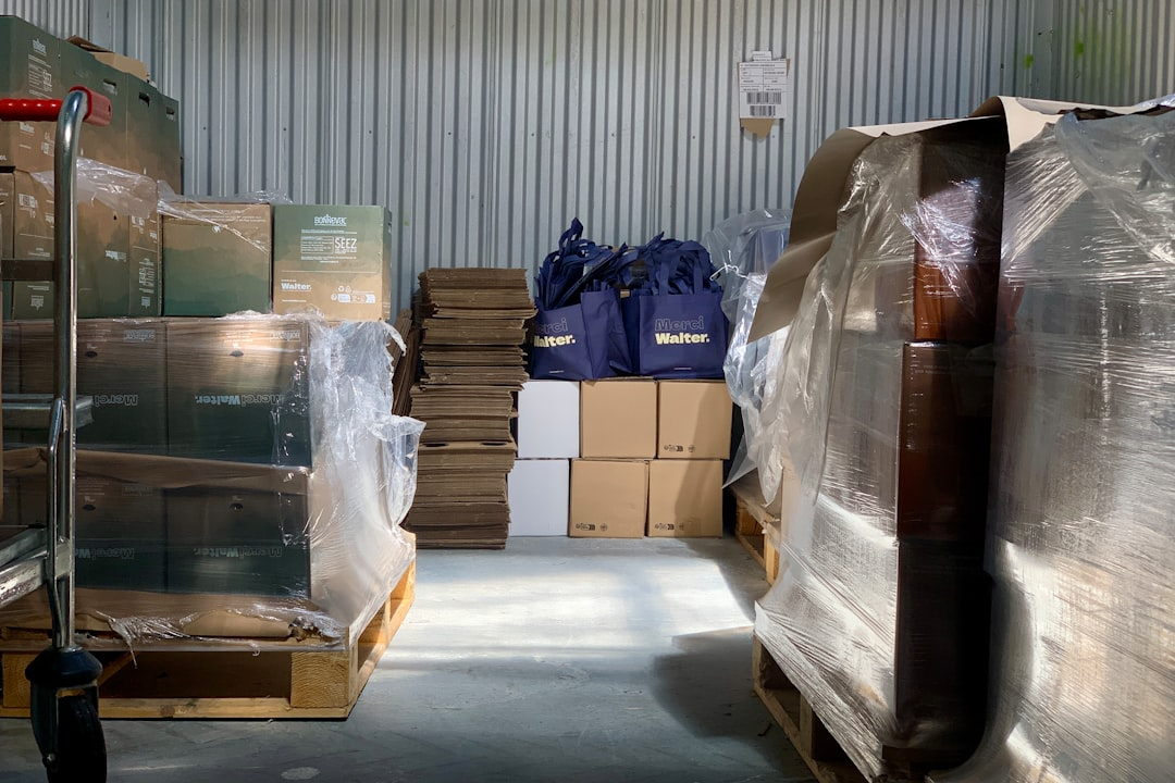 small business owner packing shipping boxes with laptop