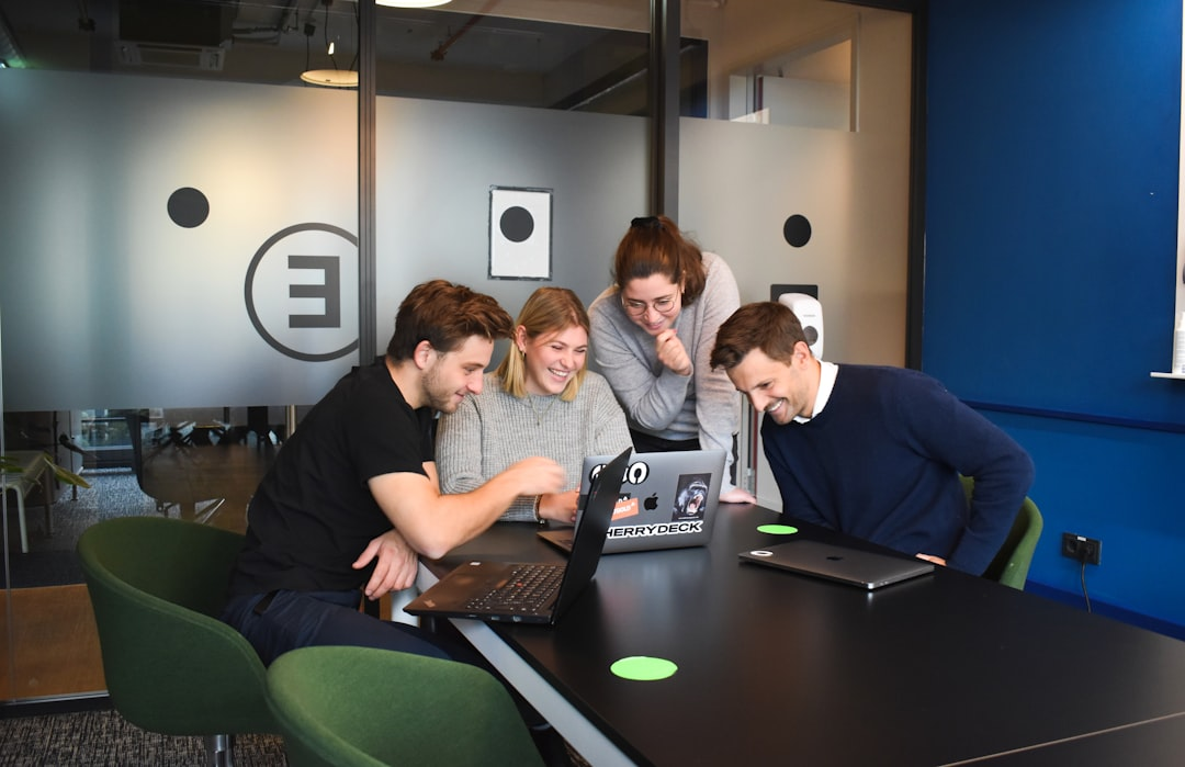team collaborating around laptop modern office
