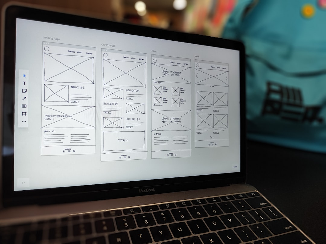 web designer workspace laptop with UI sketches and tools