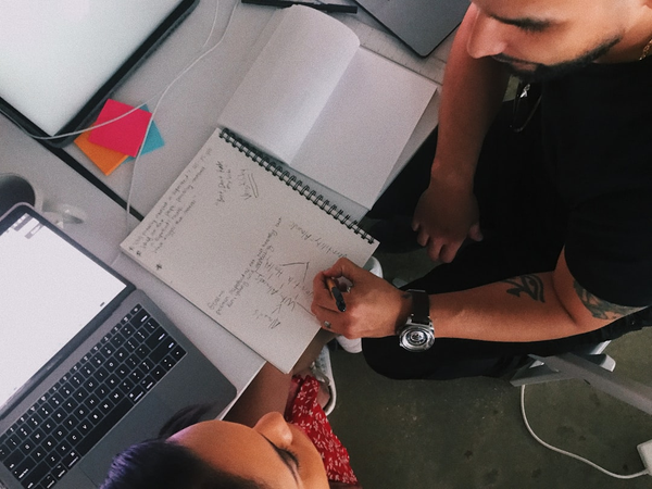 team collaborating around a laptop with charts and spreadsheets