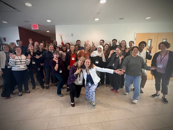 About 36 academics make goofy faces / poses in a group photo