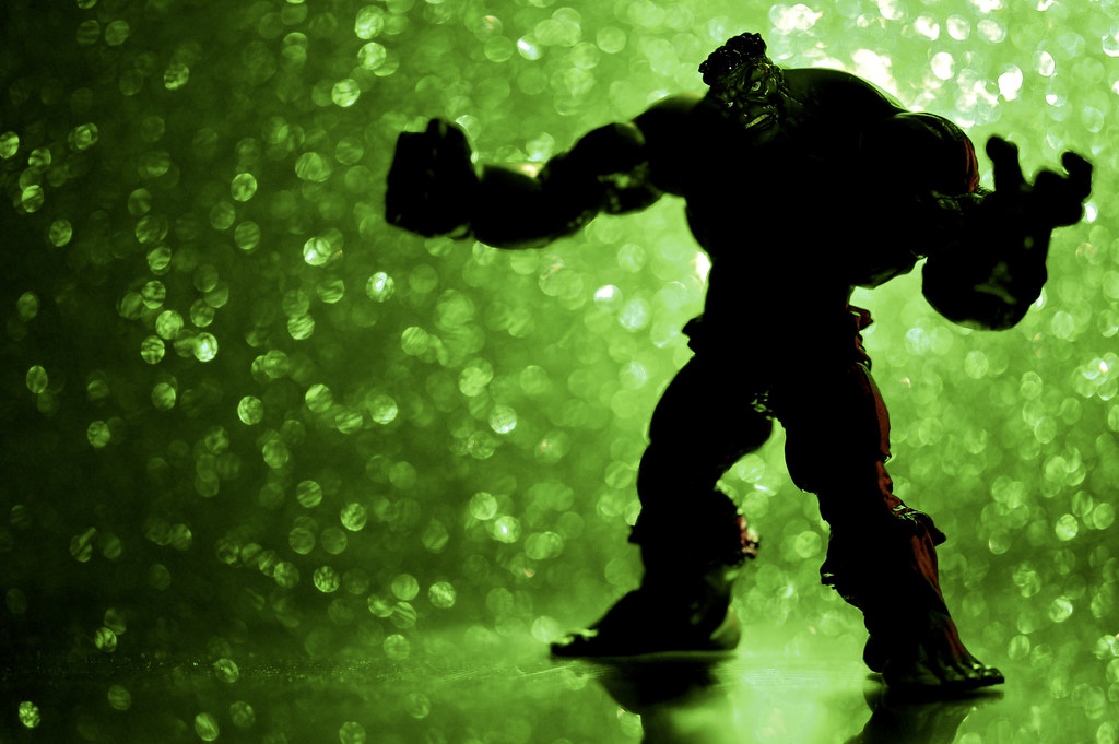 a rendering of a hulking green monster which is obscured with a green backlit background