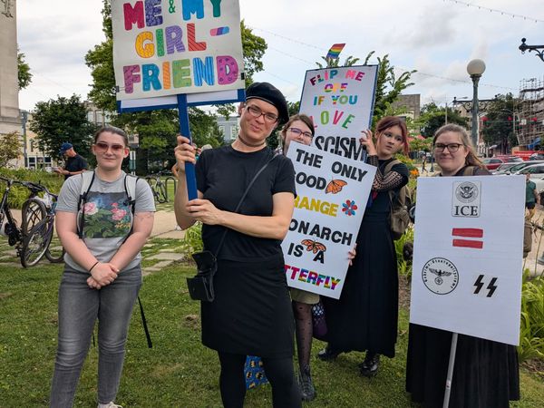 a group of protestors holding signs about love, U.S. ICE agents being like SS nazis, and anti-fascism