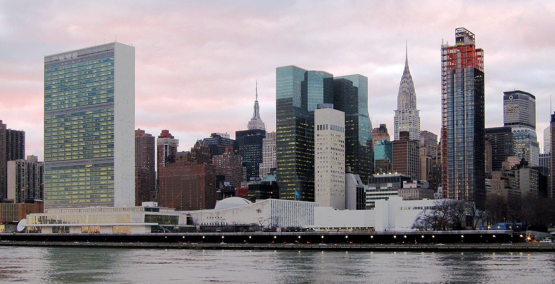 Image depicting the U.N. Headquarters Building and the New York City skyline.