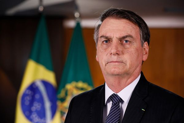 Image of former President Jair Bolsonaro of Brazil, standing in front of the Brazilian flag.