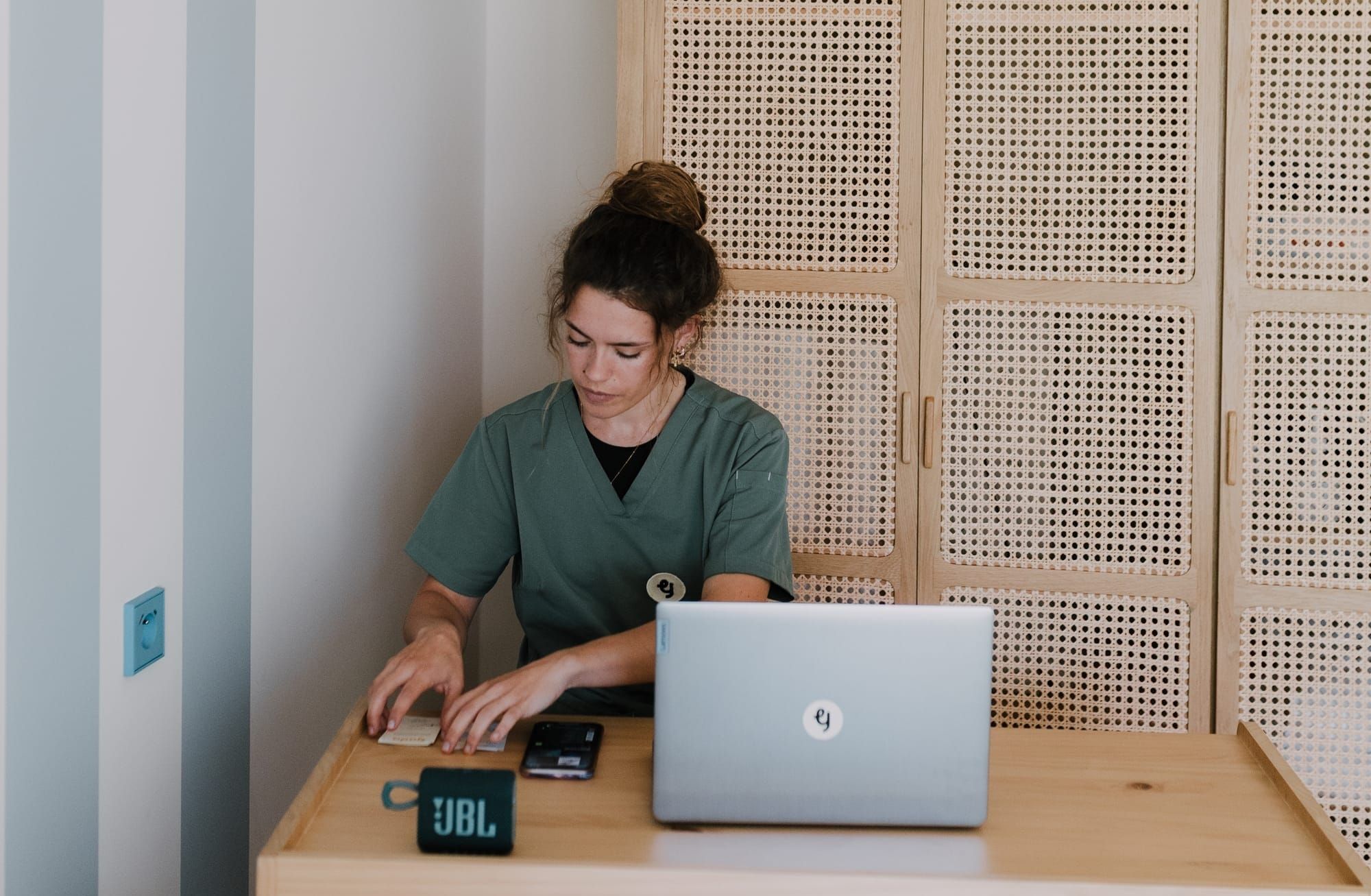 Professionnelle de santé en consultation dans un centre périnatal, travaillant sur ordinateur dans un cabinet lumineux dédié à l’accompagnement des parents et des bébés.
