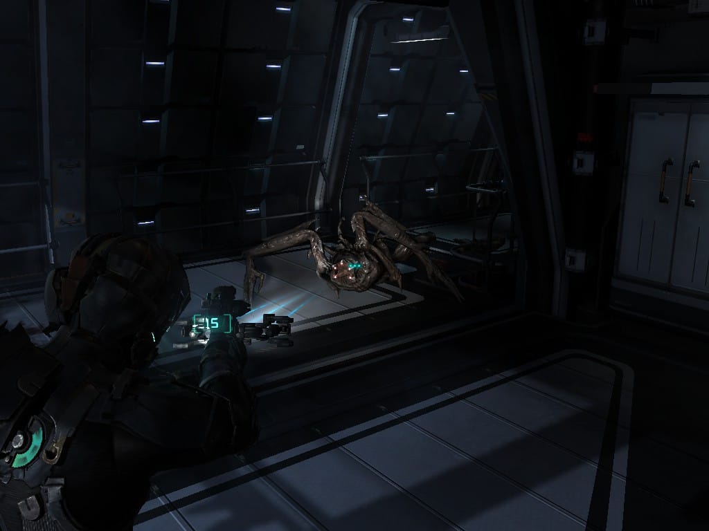 The Ubermorph, a slimey grey spider-like creature with glowing eyes and pincers, crawls towards the player after having several limbs shot off.