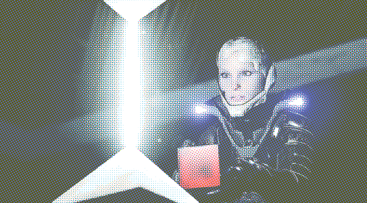 Player character En holds a red cube, and stares towards a white beam of light. 