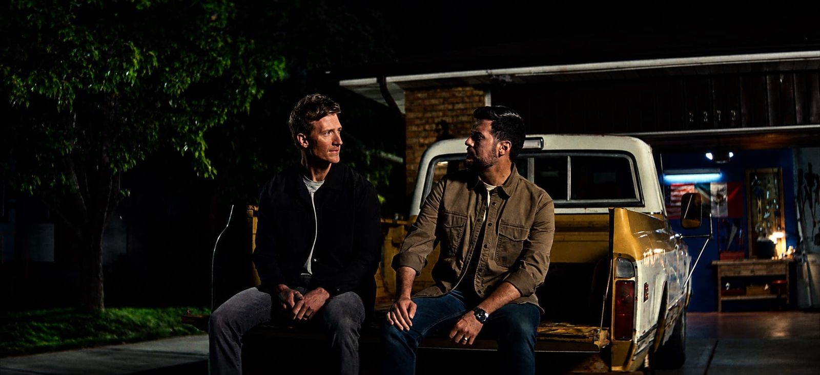 Two neighbors talk on a pickup tailgate at night, a still from Brotherhood