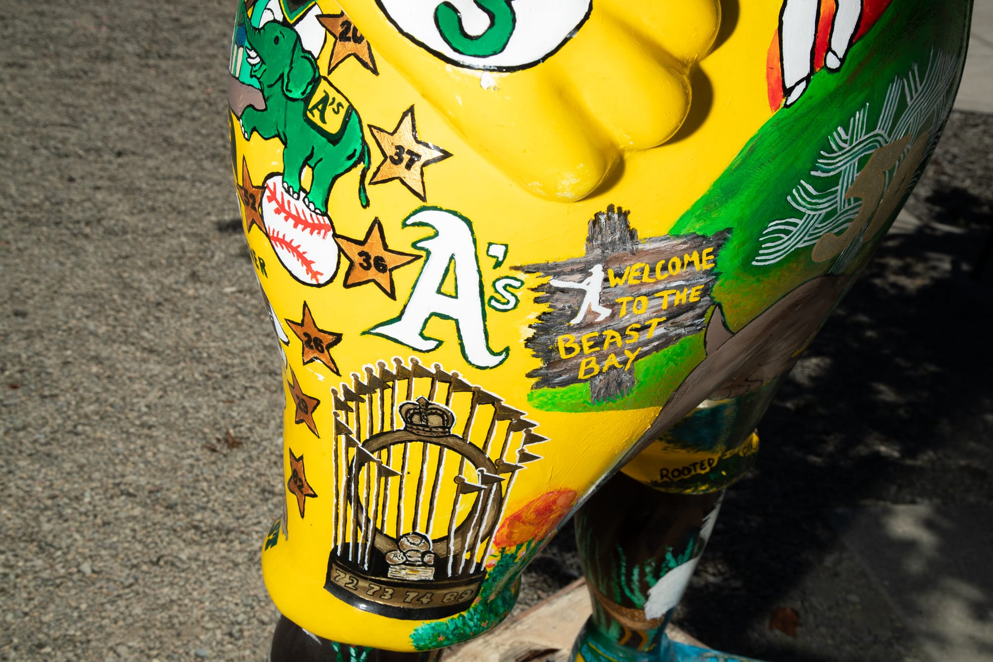 Close-up of an anthropomorphic elephant statue's thigh, featuring the Oakland A's logo: "A's"
