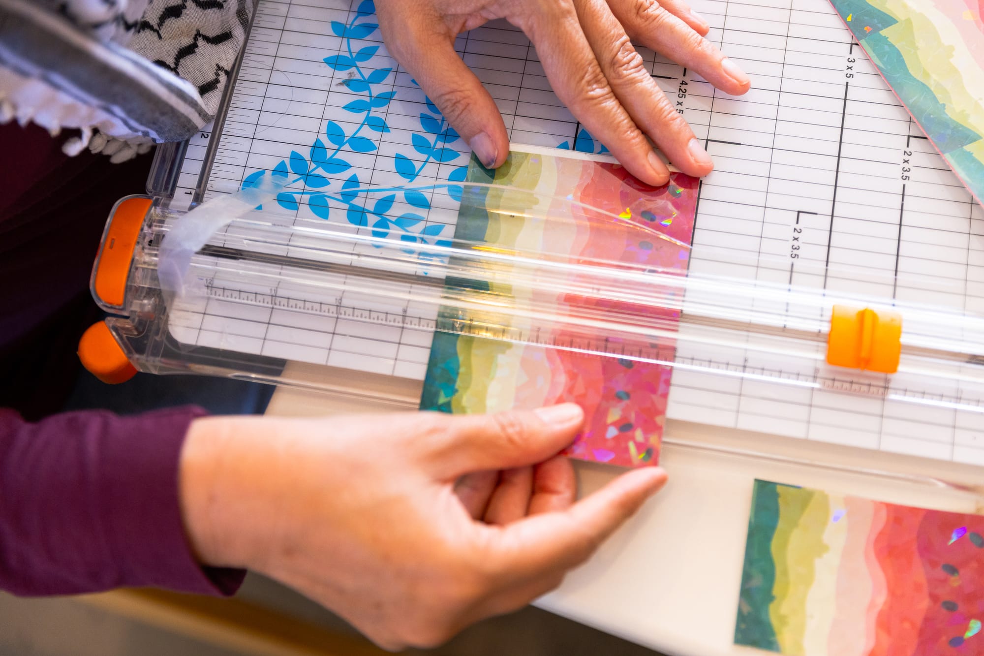 close-up of hands making watermelon stickers with a paper cutter